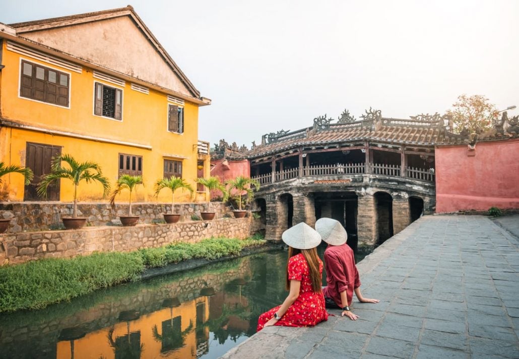 Travel couple with Japanese Covered Bridge, in Hoi An, Vietnam.