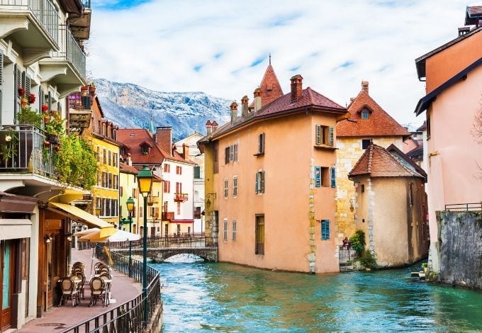 A small water canal in Annecy, France, lined with pastel-hued buildings.