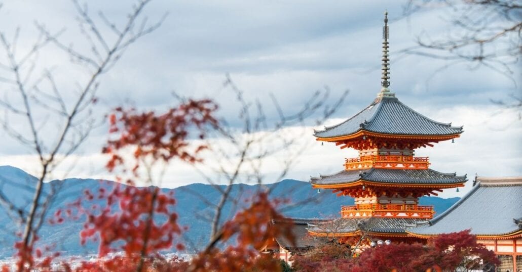 A red temple in Kyoto, Japan, during fall.