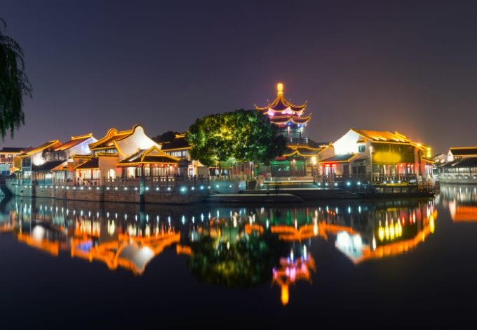 The Grand Canal in Suzhou, China, lined with lighted houses at night.