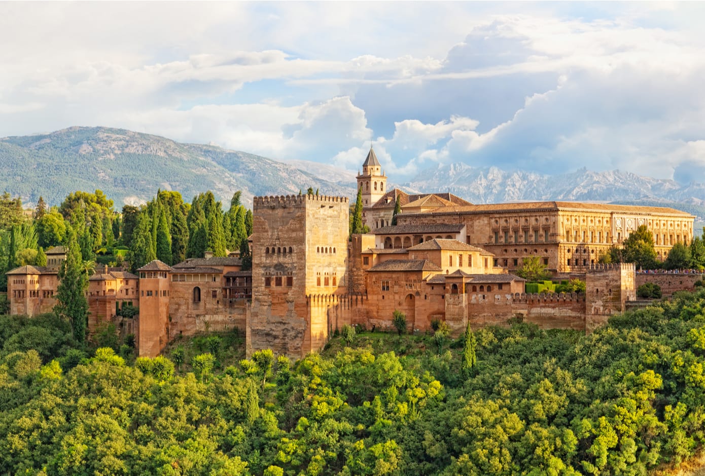 The ancient Alhambra fortress surrounded by a forest in Granada, Spain.