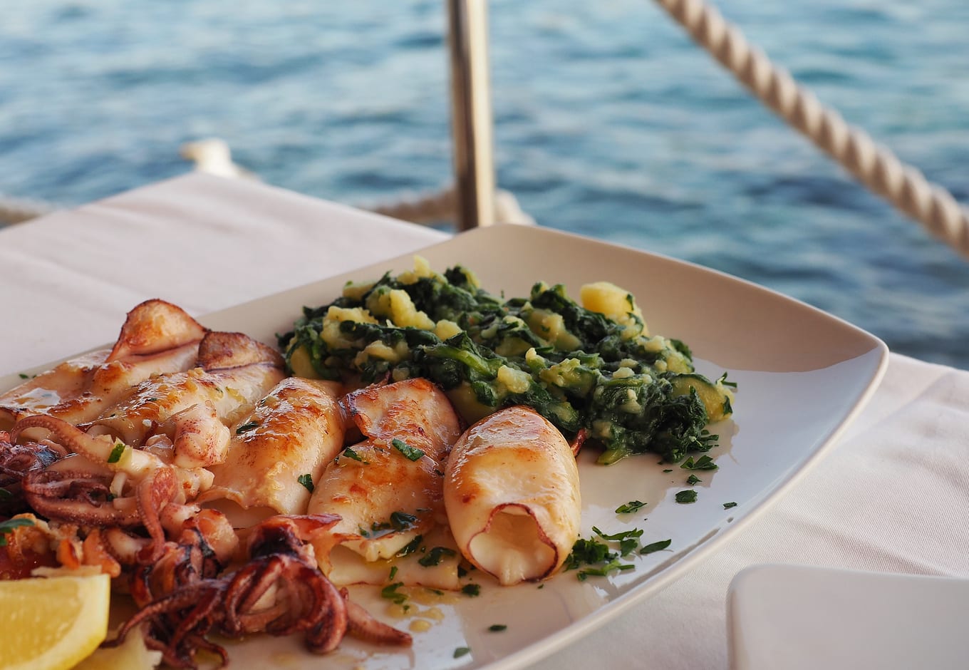 A plate with blitva and grilled squid, a traditional Croatian dish.