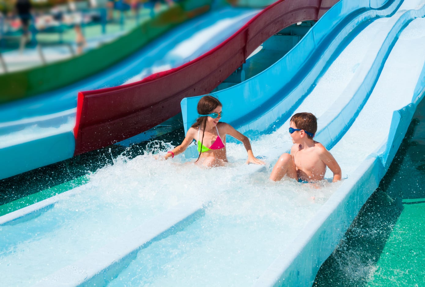 Two kids having fun at a water slide.