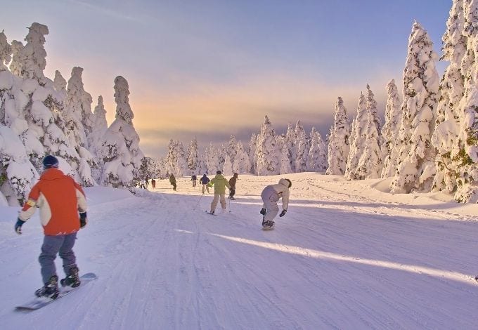 A group of people downhill skiing in a mountain.