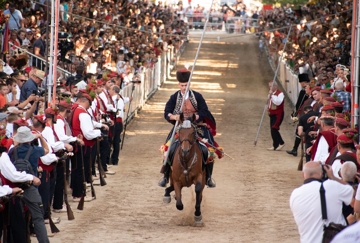 Alkar on his decorated horse galloping, hitting the metal ring with his spear during Sinjska Alka, tournament, in Sinj