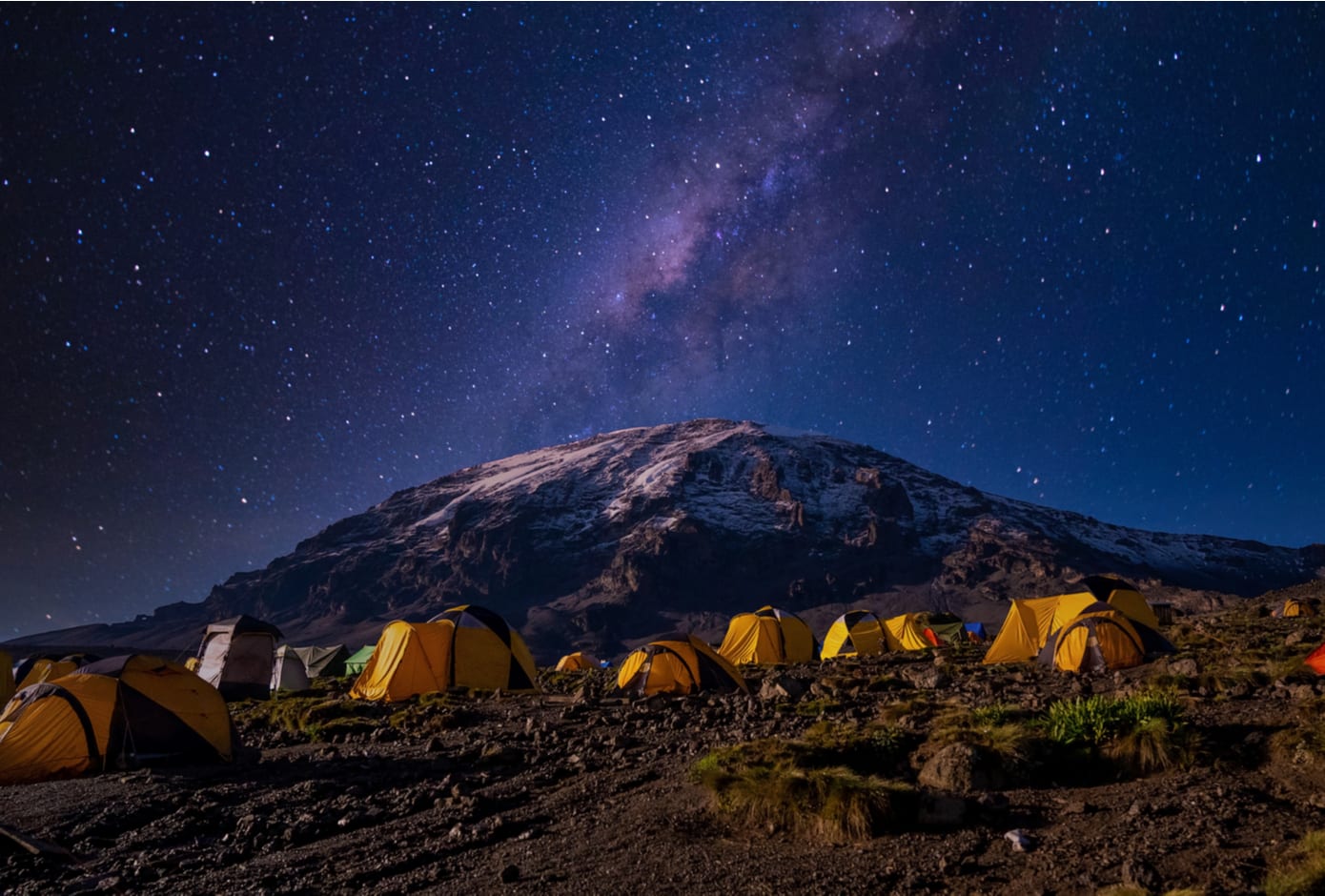 Night view of the milky way over mount Kilimanjaro, Tanzania with many tents at the base camp.