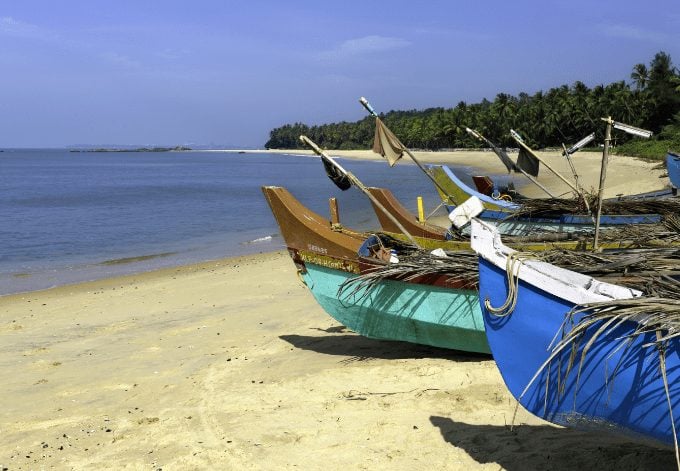Cherai Beach, Thottada, Kannur, Kerala, India. Fishing boats moored on the beach on a beautiful sunny day along the Malabar Coast overlooking the Arabian Sea.