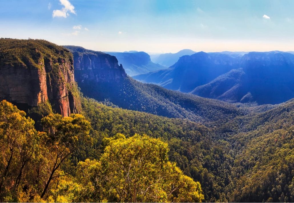Bridal vale waterfall from Govett leap lookout towards Pulpit rock and surrounding sandstone mountain ranges in Blue Mountains on a sunny morning.