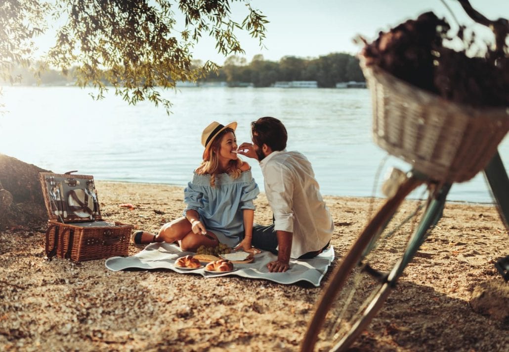 Couple on a romantic picnic by a lake.
