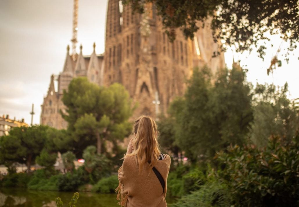  A girl from the back enjoying the view of the Sagrada Familia, in Barcelona, Spain. familia