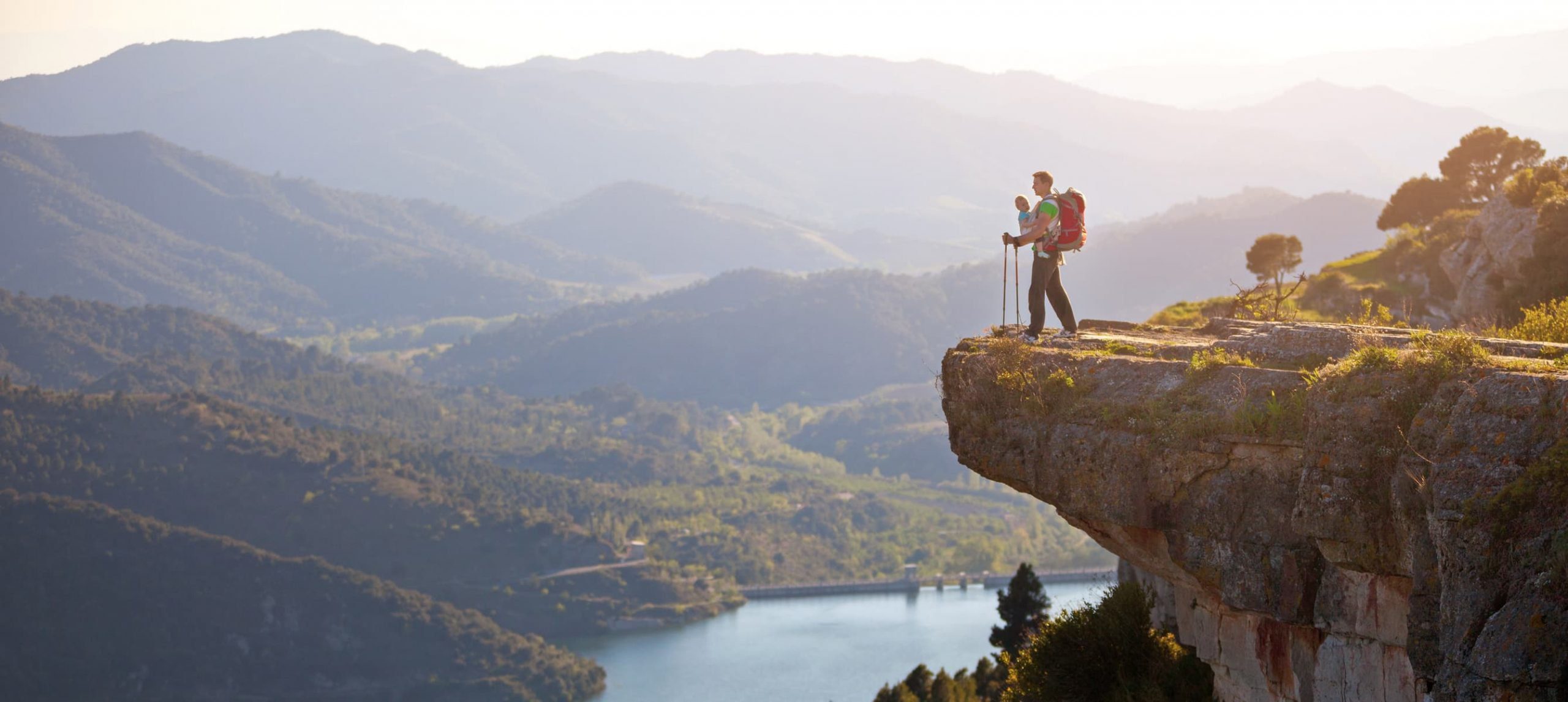 Hiker with baby relaxing on cliff and enjoying valley view. Siurana, Spain