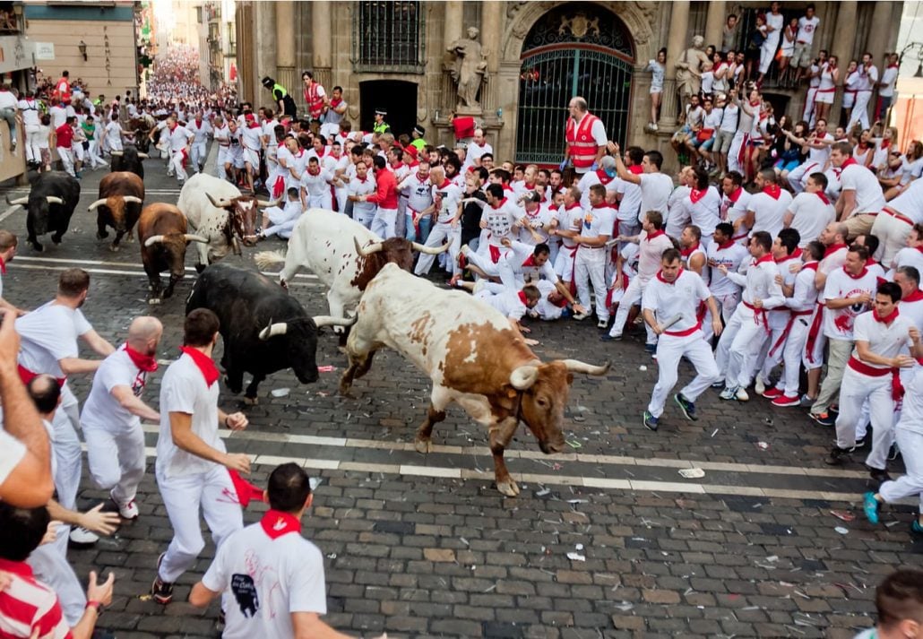 Unidentified men run from bulls in street Estafeta during San Fermin festival in Pamplona, Spain.