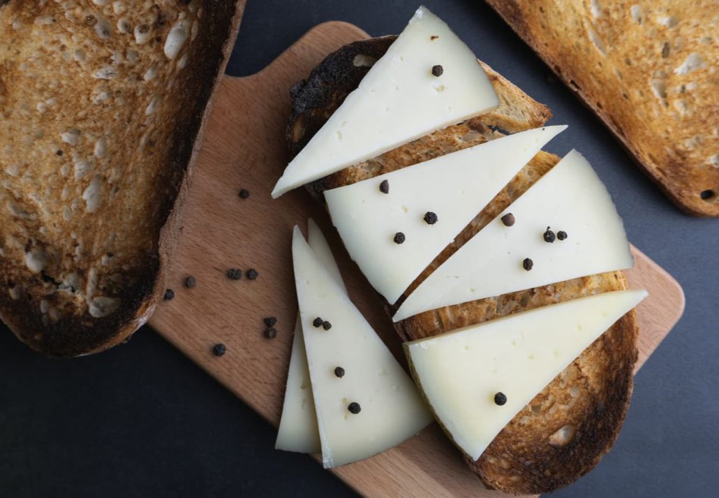 Typical Spanish cured Manchego cheese with black pepper.