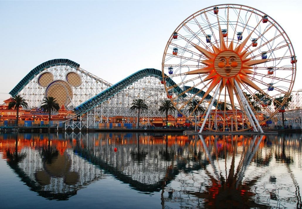 The rides or Paradise Pier in Anaheim California are reflected in the man-made lake.