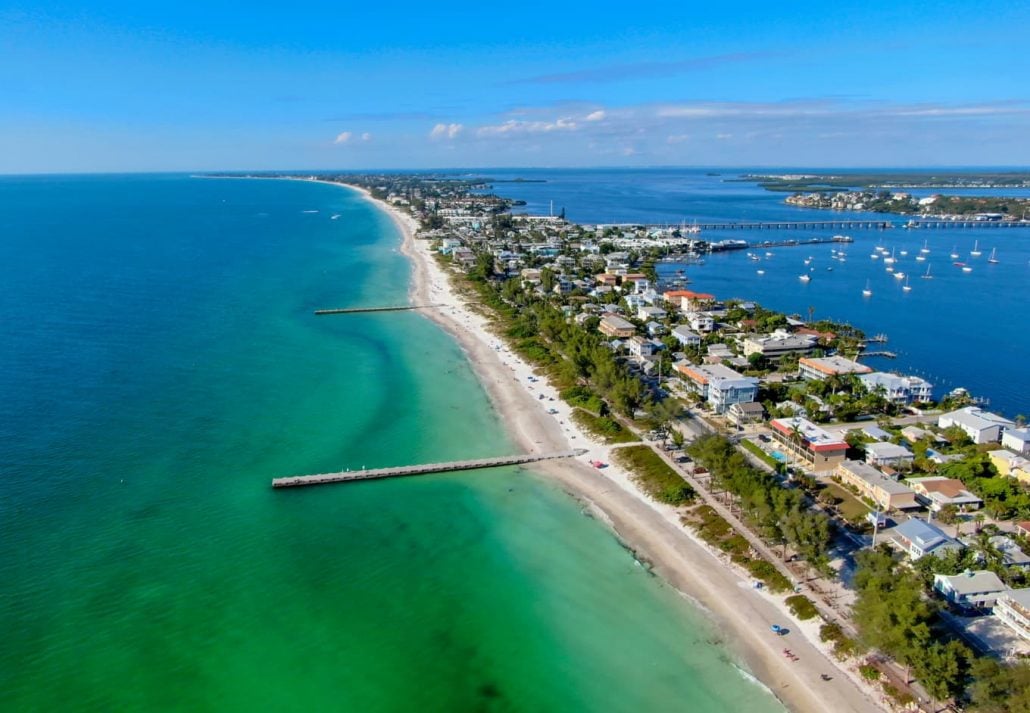 Aerial view of Cortez beach withe sand beach and his little wood pier on blue water, Anna Maria Island, Florida, USA