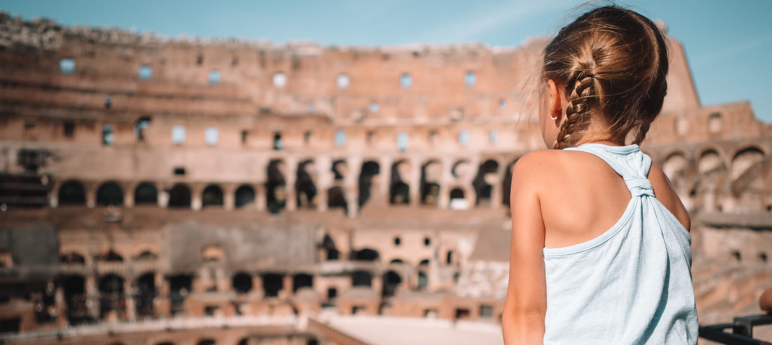 A little girl marveling at the Colosseum, in Rome, Italy