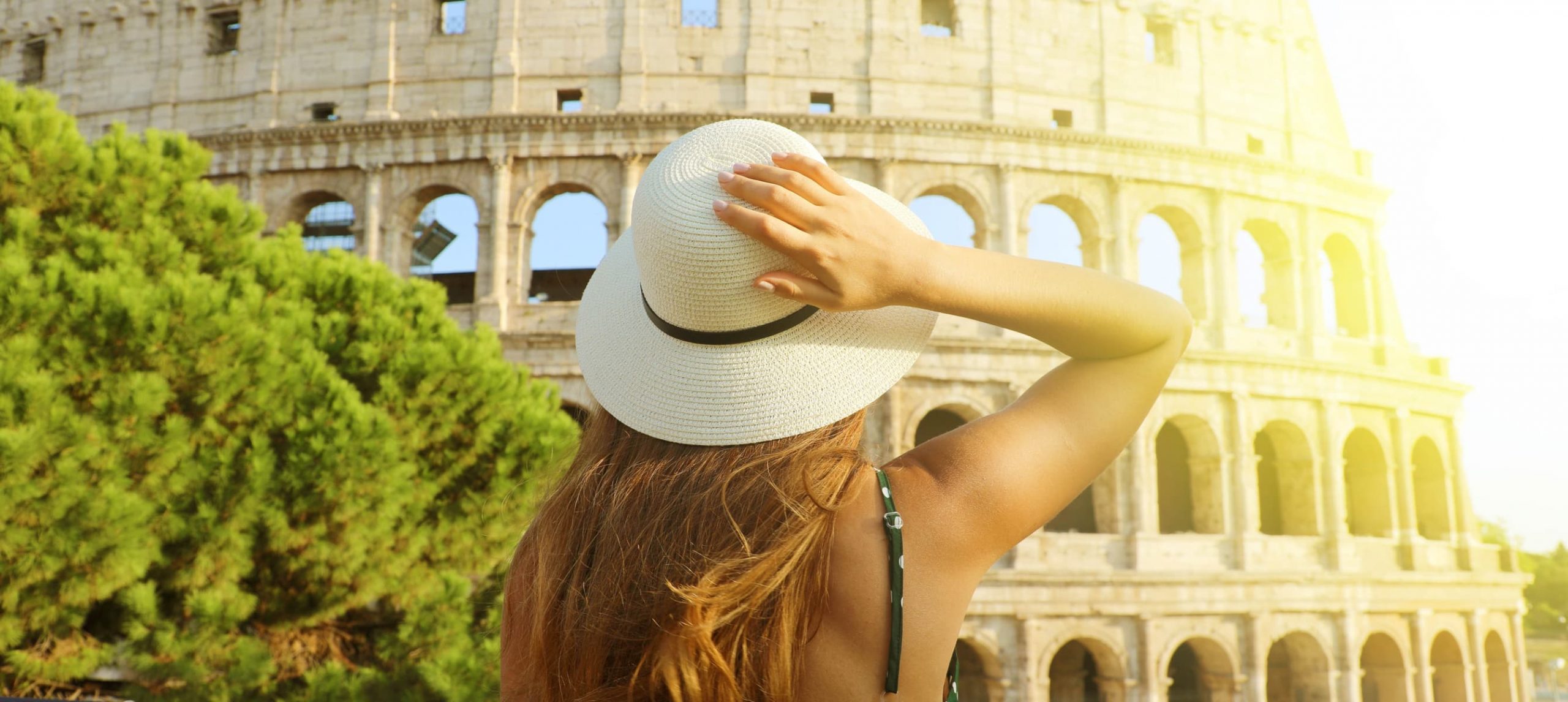 Young woman marveling at the Colosseum, in Rome.