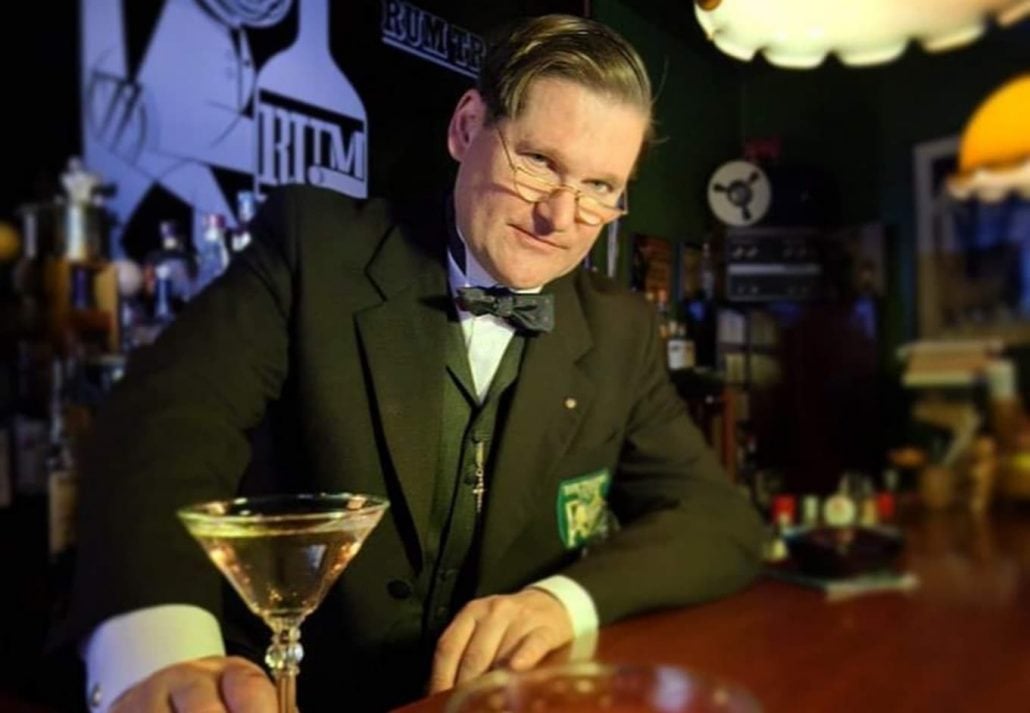 Mr. Scholl facing front and serving a cocktail drink at the Rum Trader bar in Berlin