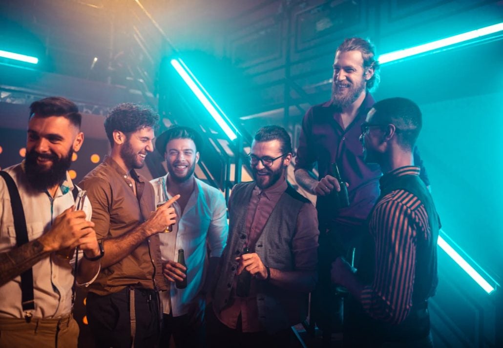 A group of men chatting and laughing at a nightclub