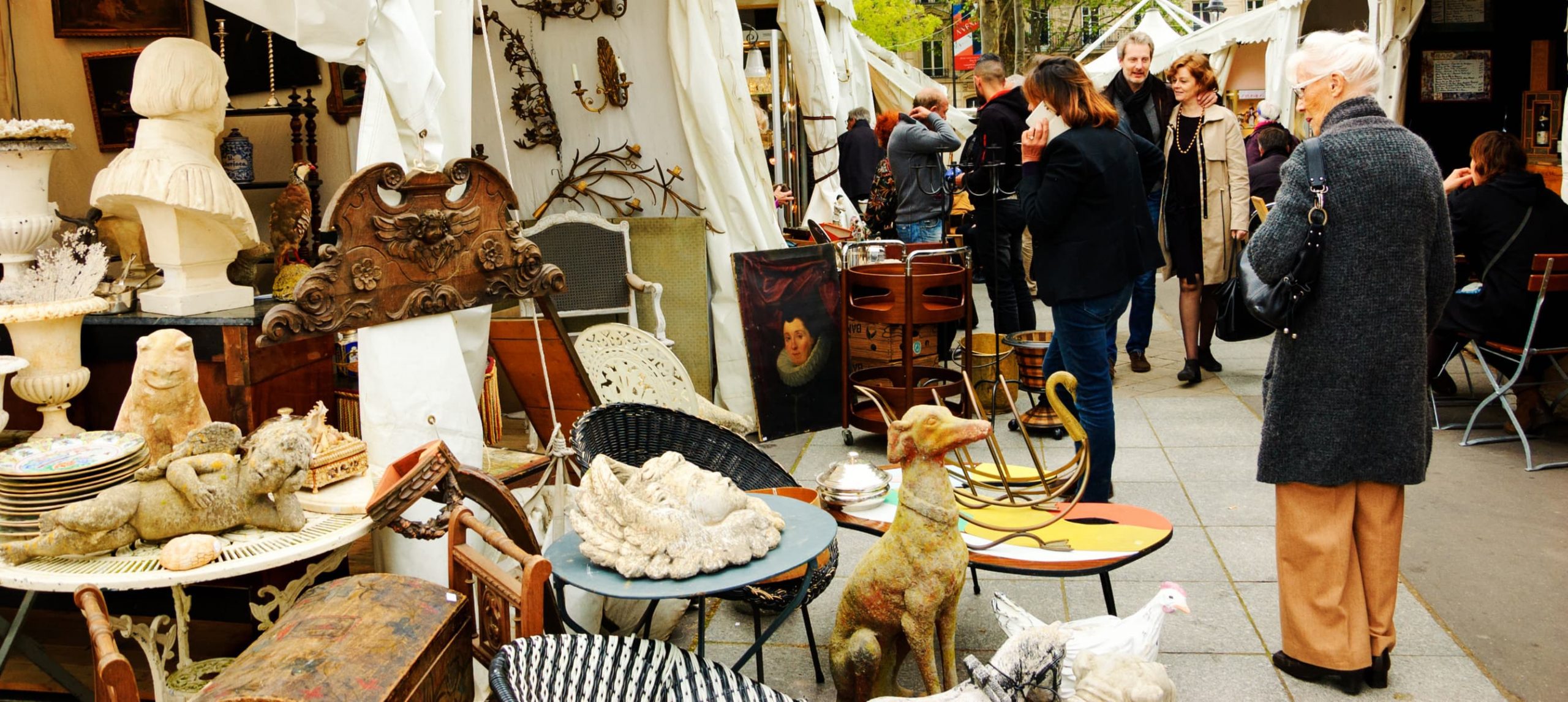 Market stall full of antique and people passing by