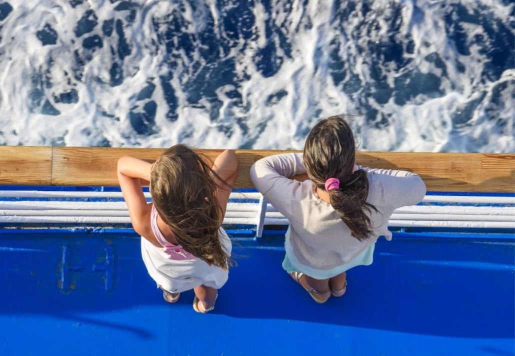 Two girls on a ferry looking at the water