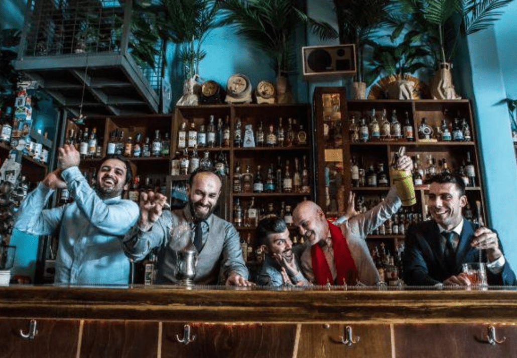 Bartenders celebrating and happily mixing drinks