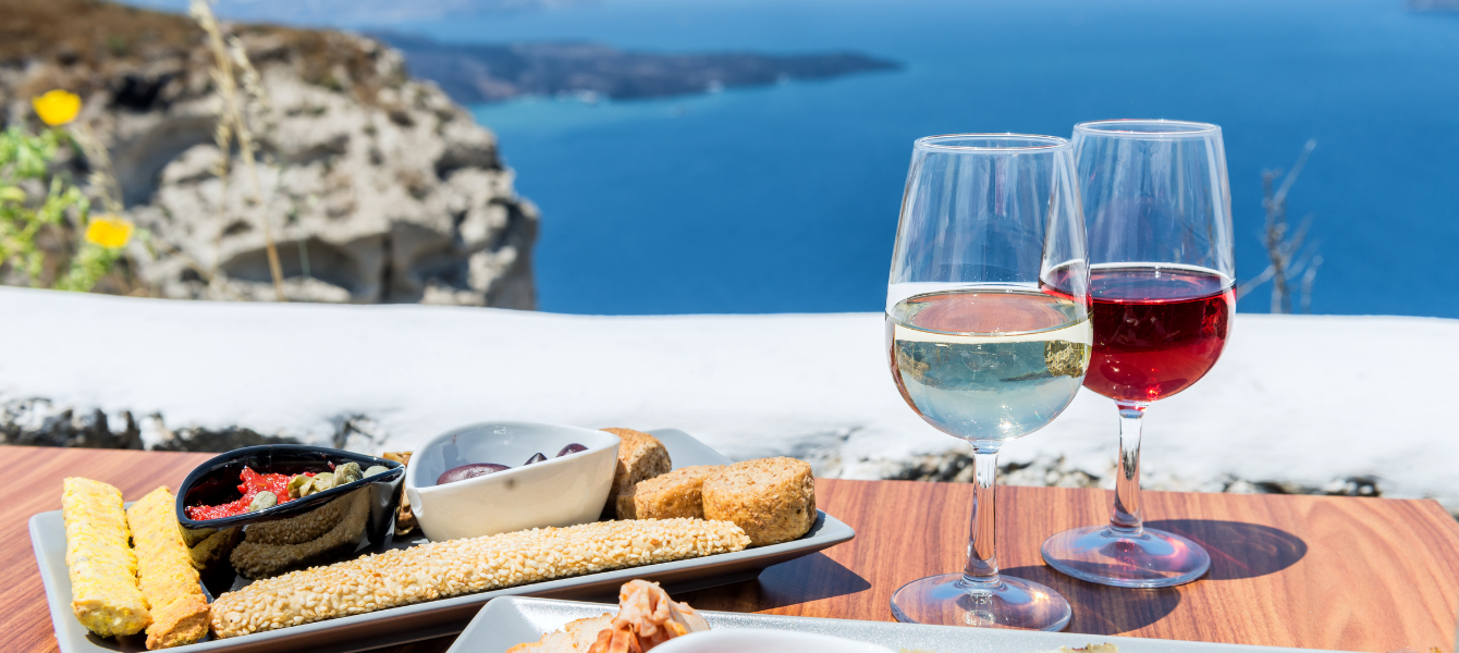 Wine glasses and cheese board overlooking sea in Santorini