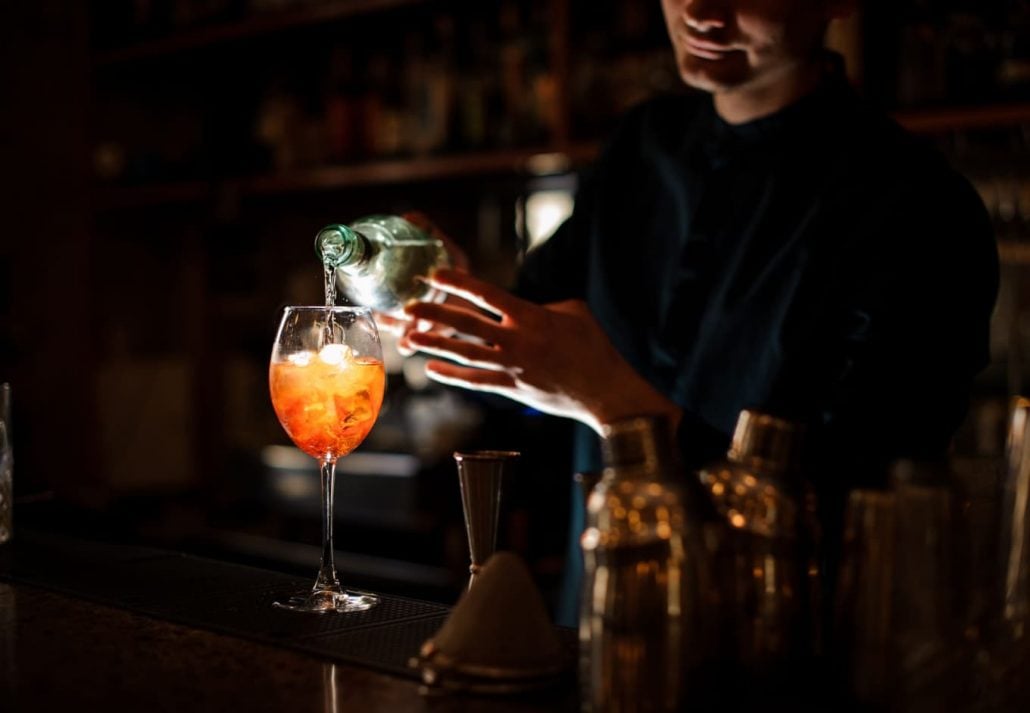 A bartender pouring an orange drink