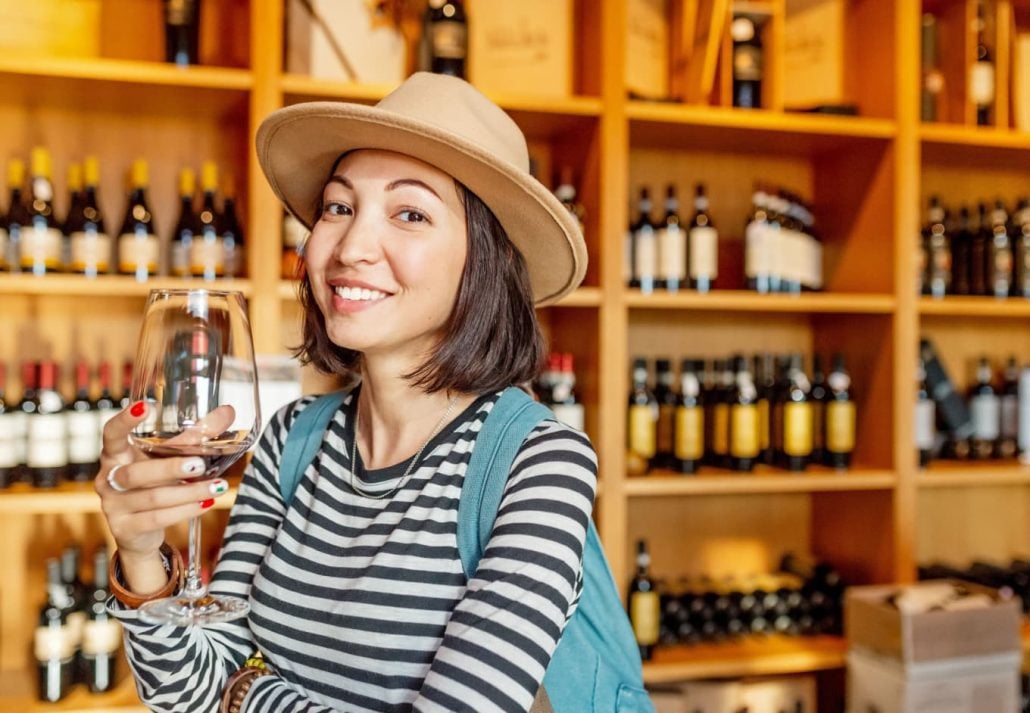 A woman having a glass of wine at a wine shop