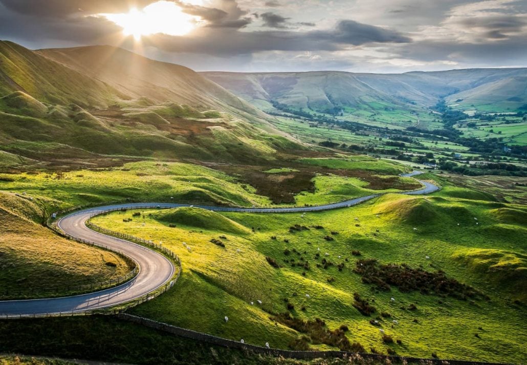 A winding road surrounded by rolling hills on the English countryside.