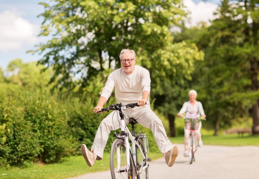 an older man riding a bike at a park
