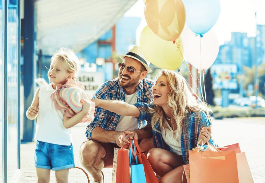 family members holding bags and shopping