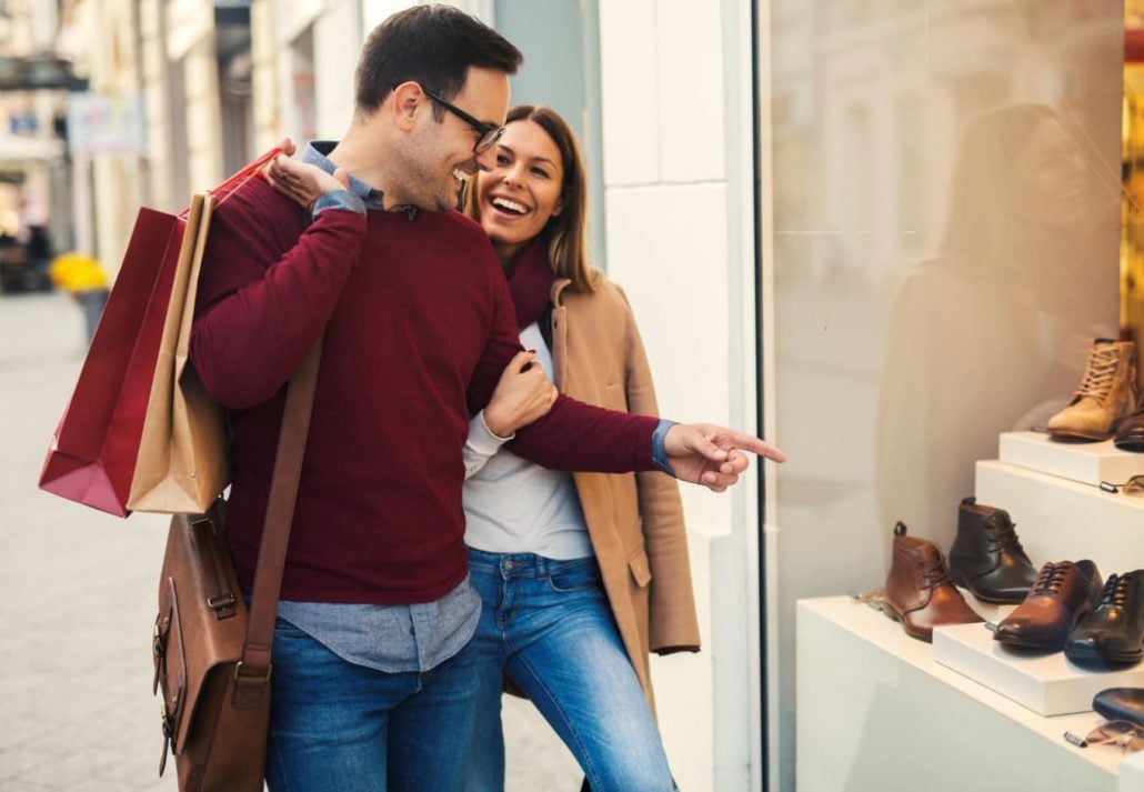 a couple walking on the street window shopping