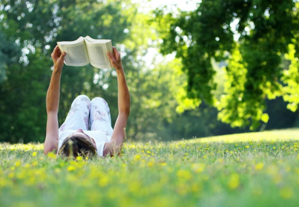 a woman reading a book in the park