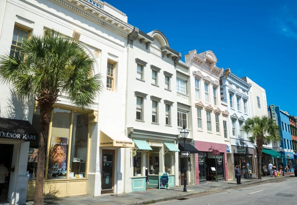 Pedestrians pass shops housed in colorful buildings lining the historic King Street shopping district, in Charleston, South Carolina.