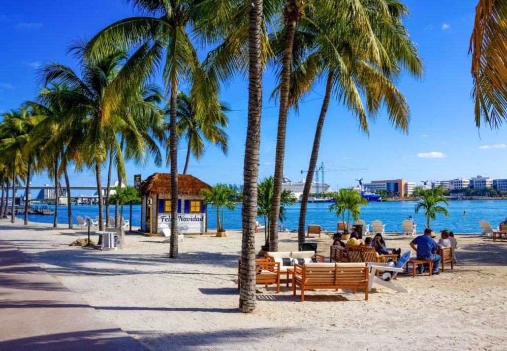 People resting at Bayfront Park with palm trees in Miami, Florida, USA.